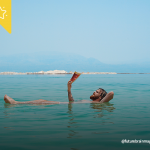 Uomo che legge in acqua al mare